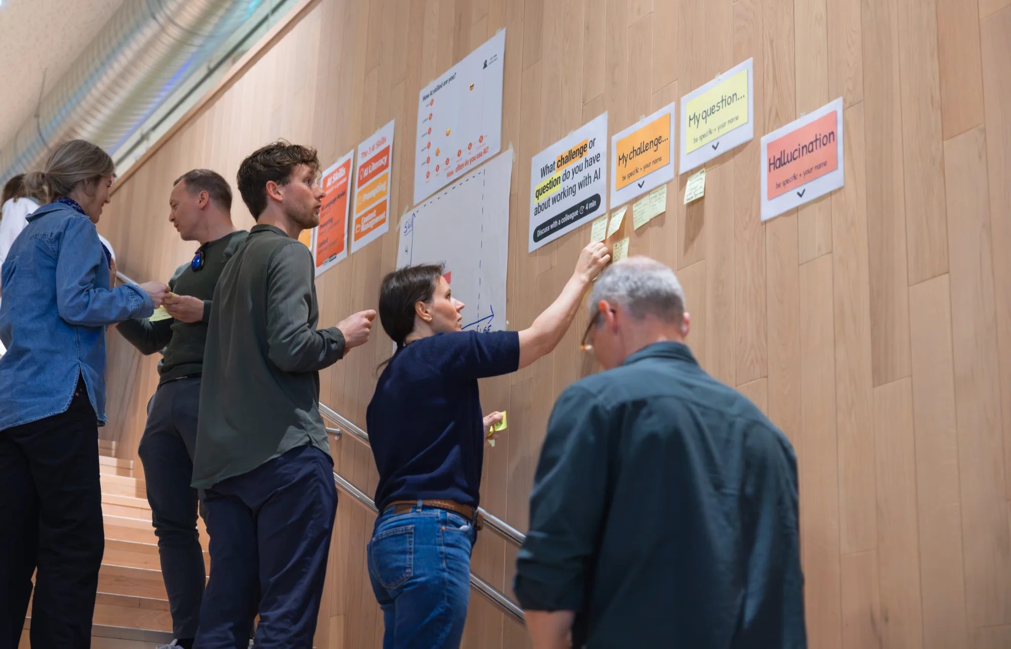 Deelnemers werken met post-its aan een prompt-oefening